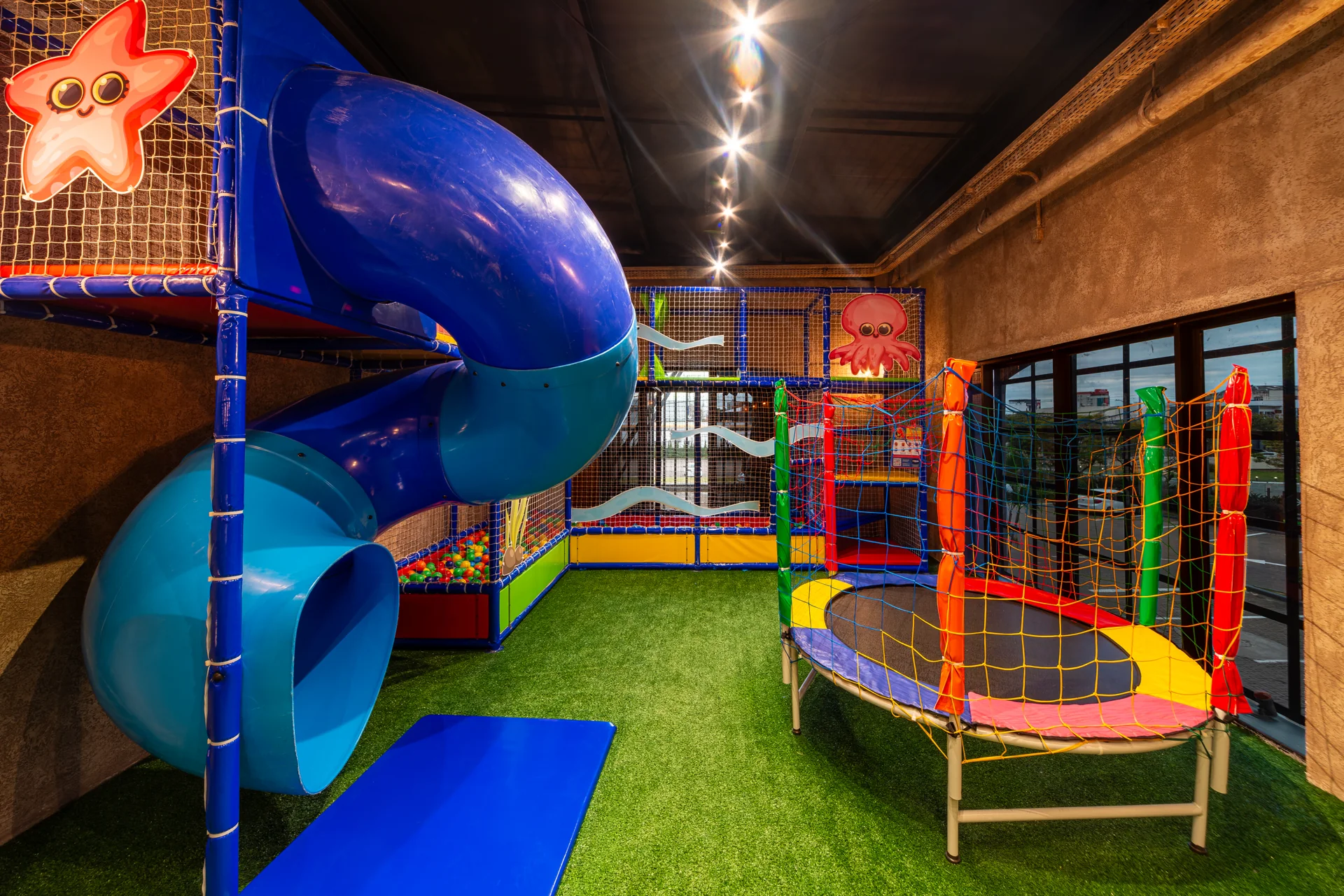 Espaço infantil do segundo piso com brinquedos e escorregador