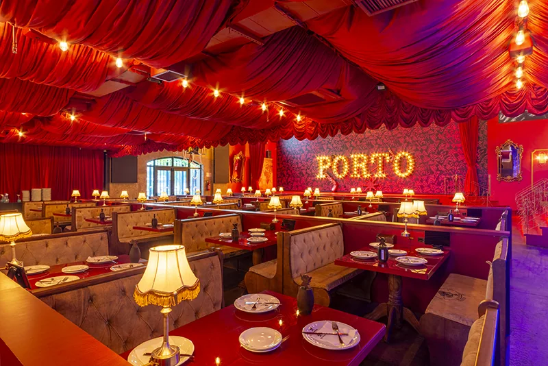 Salão do Cara de Mau Porto Alegre com decoração vermelha, lustres e mesas iluminadas